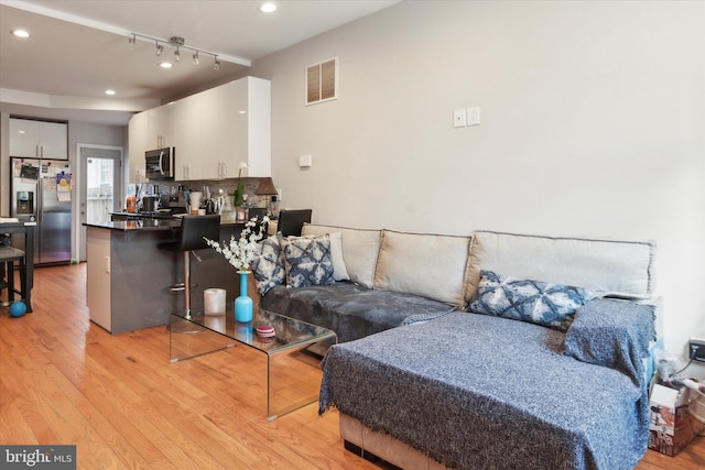 living room featuring light hardwood / wood-style flooring and track lighting