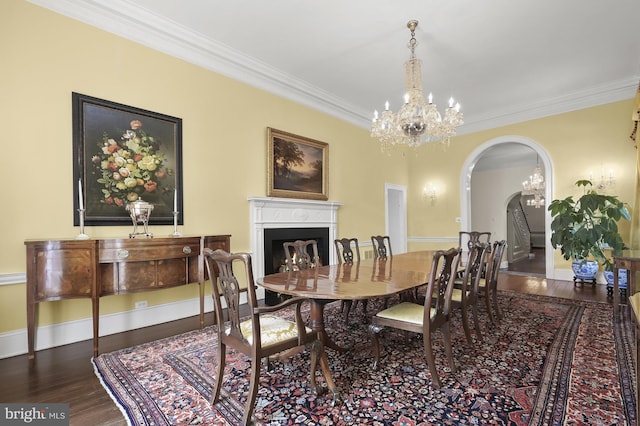 dining space featuring crown molding, an inviting chandelier, and dark hardwood / wood-style flooring