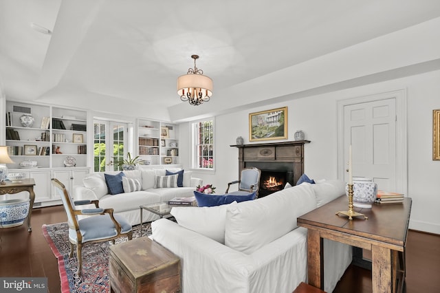 living room featuring an inviting chandelier, dark hardwood / wood-style floors, and french doors