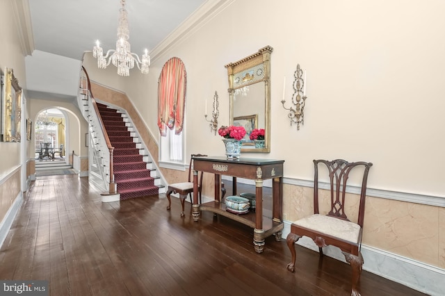 interior space featuring an inviting chandelier, crown molding, and dark wood-type flooring