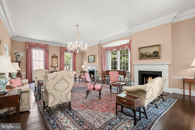 living room featuring dark hardwood / wood-style flooring, a notable chandelier, and ornamental molding