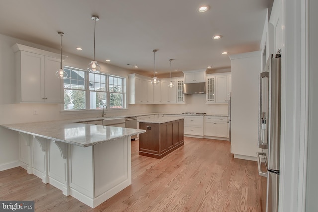 kitchen featuring decorative light fixtures, white cabinets, and light hardwood / wood-style floors