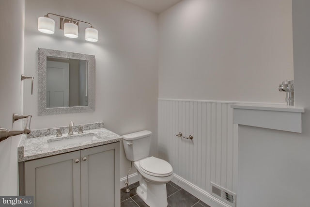 bathroom featuring toilet, tile floors, and vanity