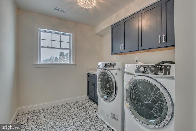 laundry room with an inviting chandelier, light tile flooring, cabinets, and separate washer and dryer