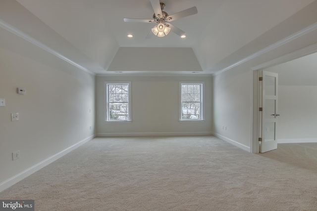 carpeted spare room featuring a tray ceiling and ceiling fan