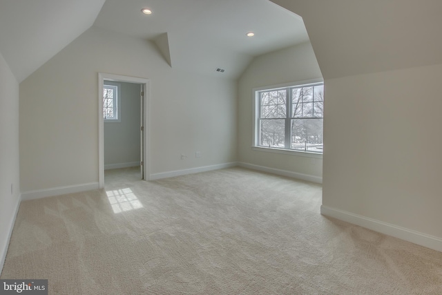 bonus room featuring light colored carpet, vaulted ceiling, and a wealth of natural light