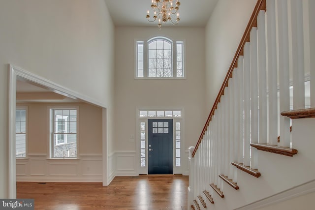 foyer with a notable chandelier, a wealth of natural light, and light hardwood / wood-style floors