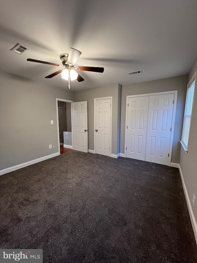 unfurnished bedroom featuring dark colored carpet and ceiling fan