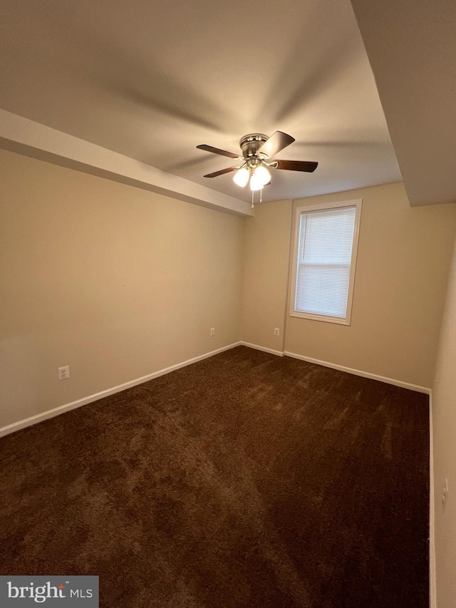 unfurnished room featuring dark colored carpet and ceiling fan