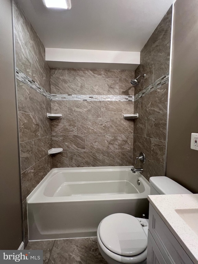 full bathroom featuring tile patterned floors, tiled shower / bath combo, toilet, and vanity