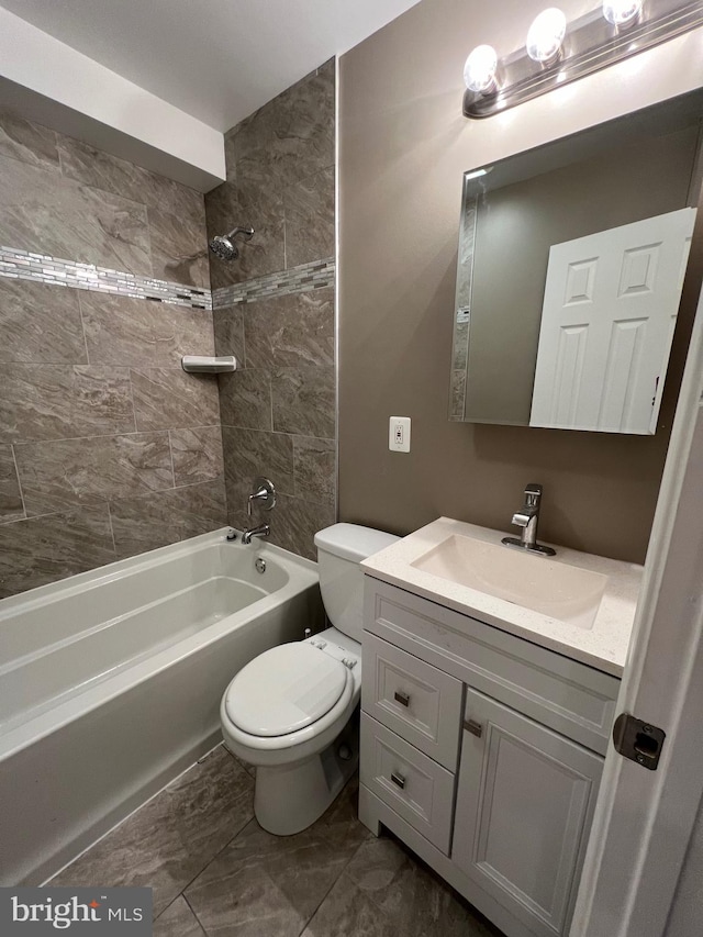 full bathroom with toilet, vanity, and tiled shower / bath