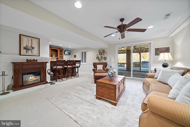 living room featuring ceiling fan, ornamental molding, and light carpet