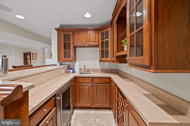 kitchen with light tile floors, beverage cooler, light stone countertops, and sink