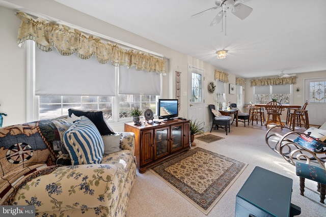 living room with ceiling fan, a healthy amount of sunlight, and light colored carpet