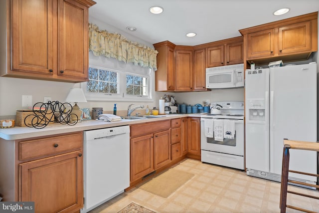 kitchen featuring white appliances, sink, and light tile flooring