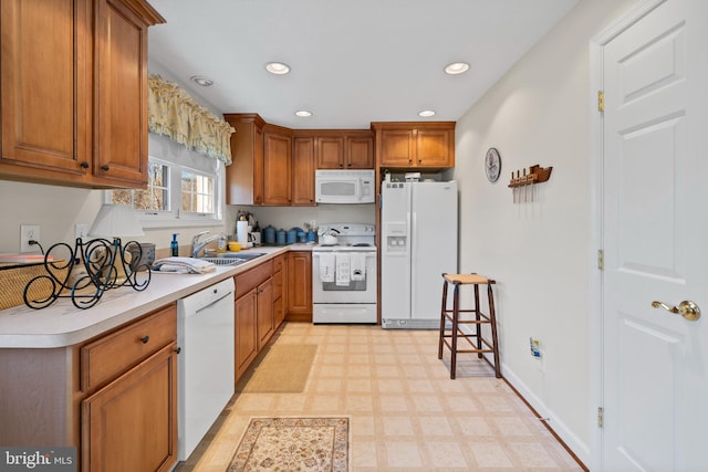 kitchen featuring light tile flooring, sink, and white appliances