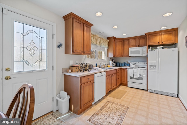 kitchen featuring light tile flooring, sink, and white appliances