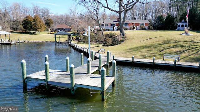 dock area featuring a gazebo, a water view, and a lawn