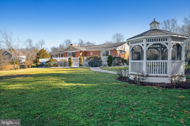 back of house with a gazebo and a yard