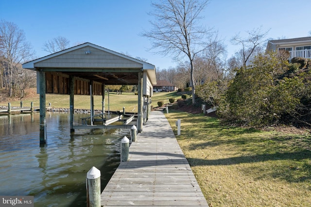 view of dock with a yard and a water view