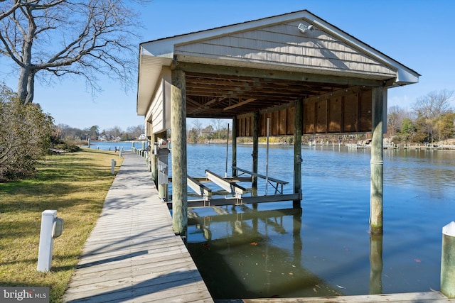 view of dock with a water view and a yard