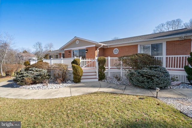 ranch-style home featuring a front yard and a deck