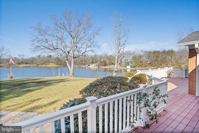 wooden deck with a water view and a lawn