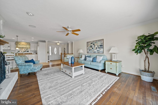 living room with ornamental molding, dark hardwood / wood-style flooring, and ceiling fan