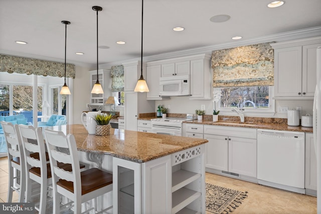 kitchen featuring white appliances, a center island, decorative light fixtures, and a healthy amount of sunlight