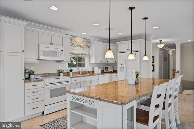 kitchen with hanging light fixtures, a kitchen island, white appliances, light tile floors, and light stone countertops