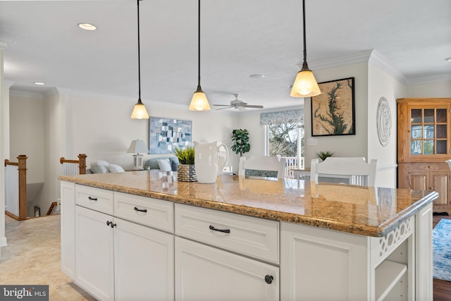 kitchen featuring light stone countertops, hanging light fixtures, ceiling fan, and white cabinetry