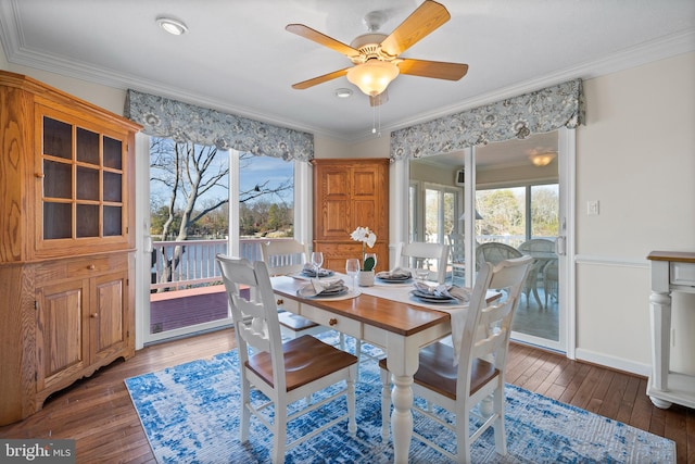 dining space with dark hardwood / wood-style flooring, ceiling fan, and crown molding