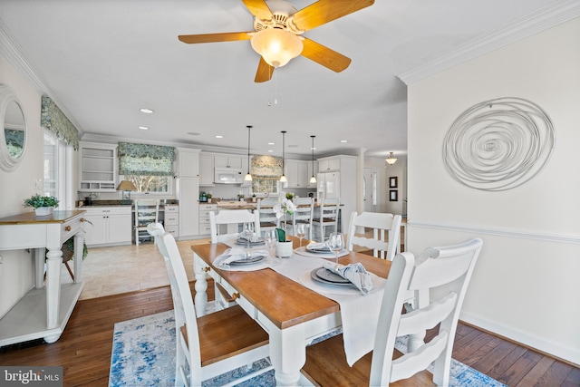 tiled dining area featuring wine cooler, ceiling fan, and ornamental molding