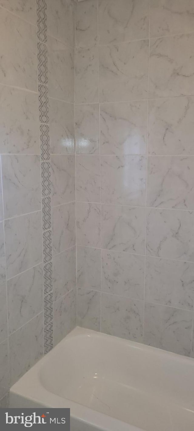 bathroom featuring tiled shower / bath