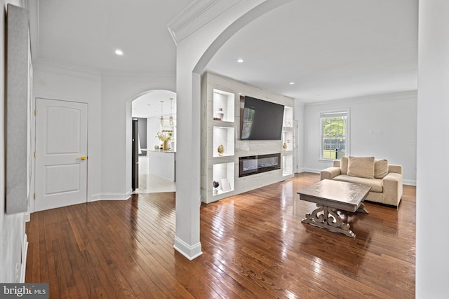 living room featuring crown molding, a fireplace, and wood-type flooring