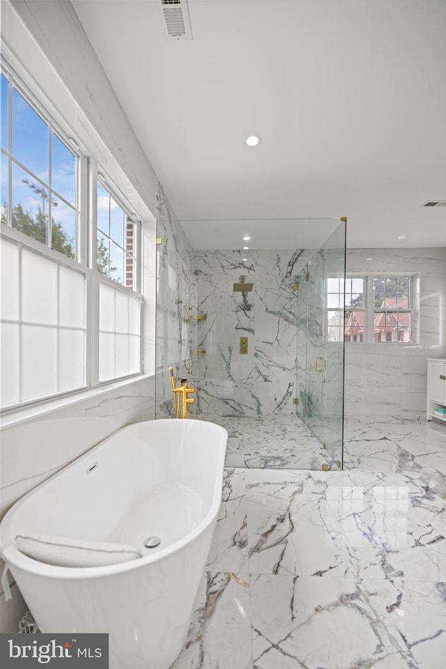 bathroom with tile walls and shower with separate bathtub