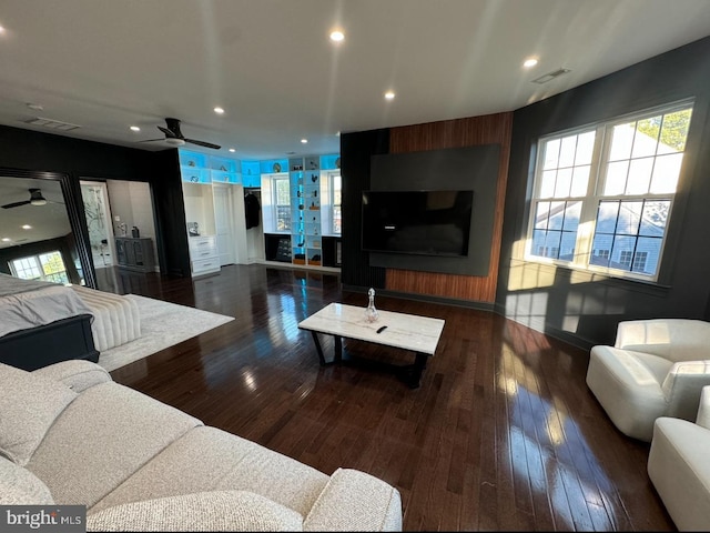 living room with ceiling fan and dark hardwood / wood-style flooring