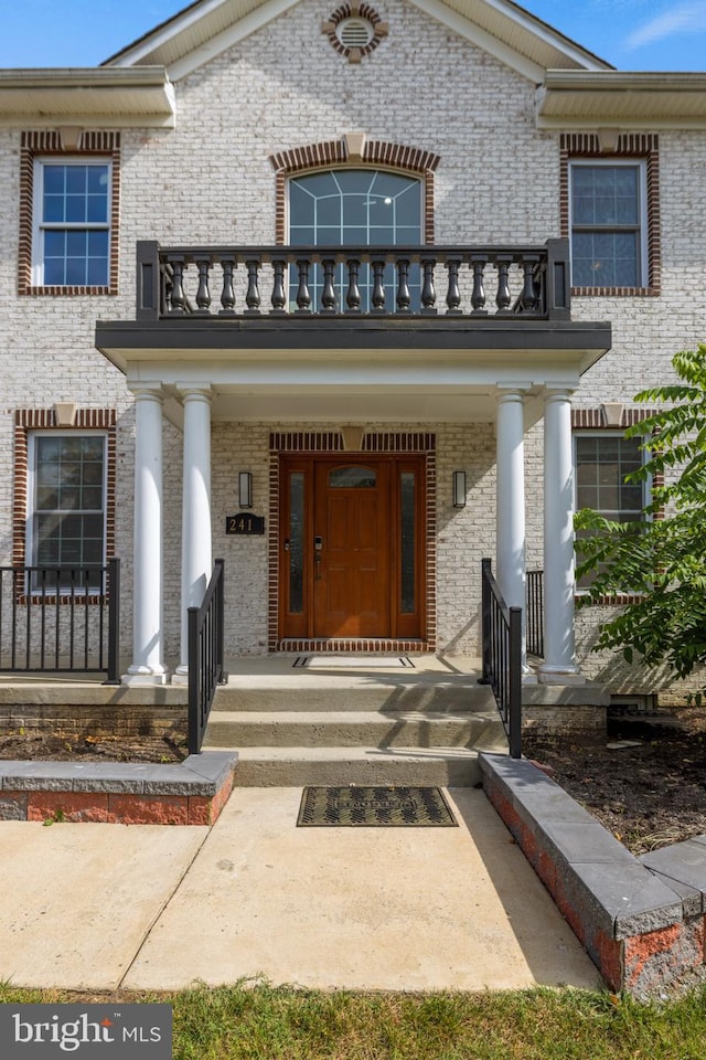 property entrance with a porch and a balcony