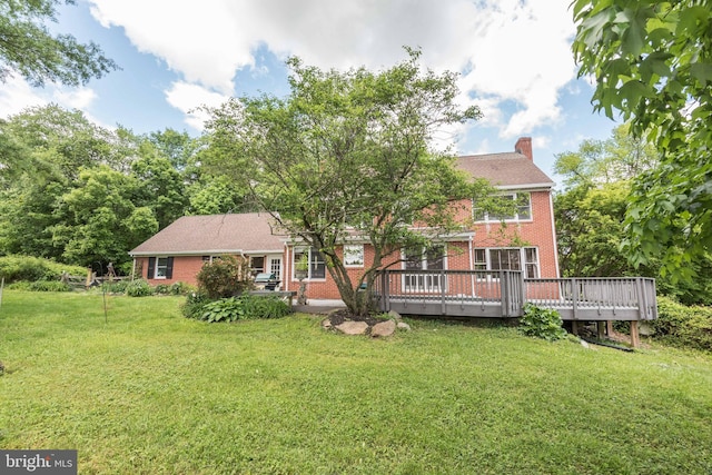 back of property with a deck and a yard