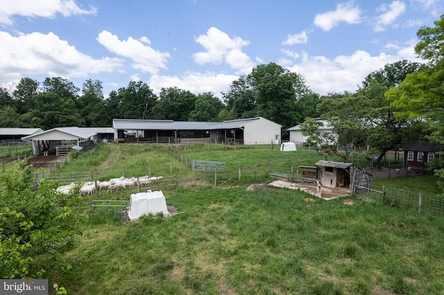 view of yard featuring an outdoor structure and a rural view