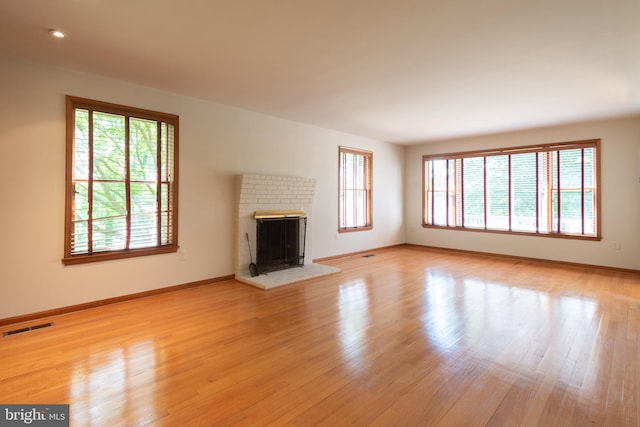 unfurnished living room with light hardwood / wood-style floors and a fireplace