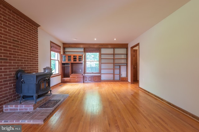 unfurnished living room featuring light wood-type flooring and a wood stove