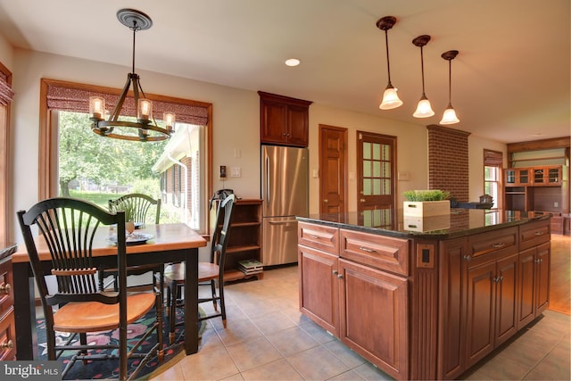 kitchen featuring stainless steel fridge, a kitchen island, pendant lighting, and light tile floors