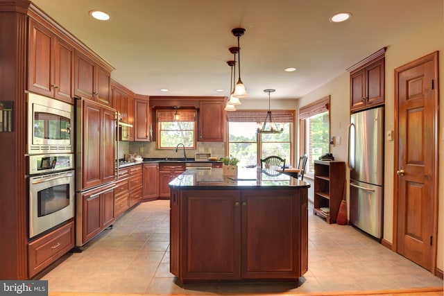 kitchen with stainless steel appliances, tasteful backsplash, light tile floors, and a kitchen island