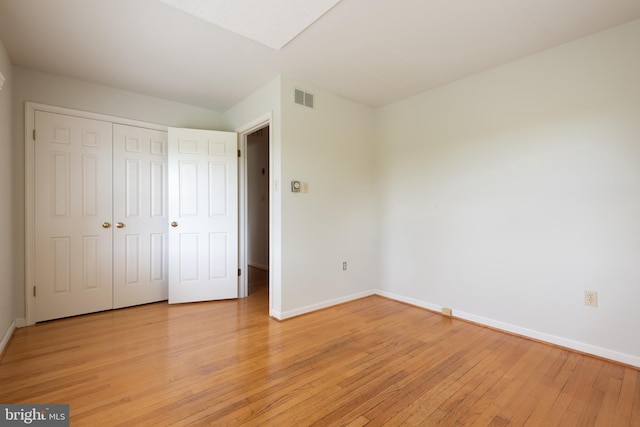 unfurnished bedroom with a closet and light wood-type flooring