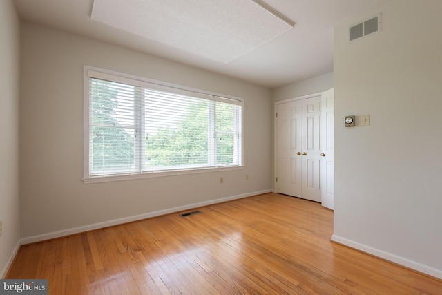 unfurnished room with light wood-type flooring