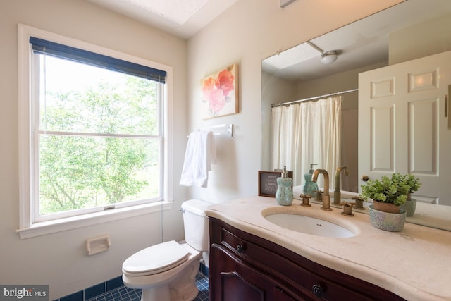 bathroom featuring tile flooring, plenty of natural light, vanity, and toilet