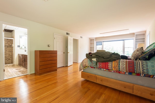 bedroom featuring ensuite bathroom and hardwood / wood-style floors