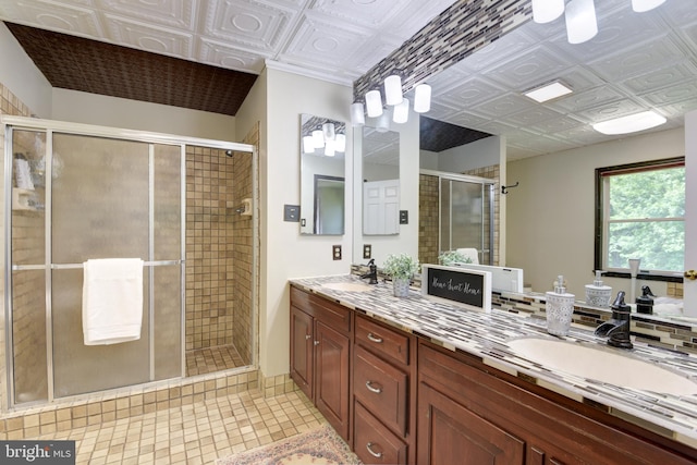 bathroom featuring walk in shower, dual sinks, and vanity with extensive cabinet space