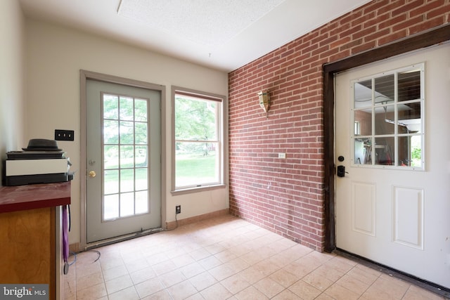 doorway to outside with brick wall and light tile flooring